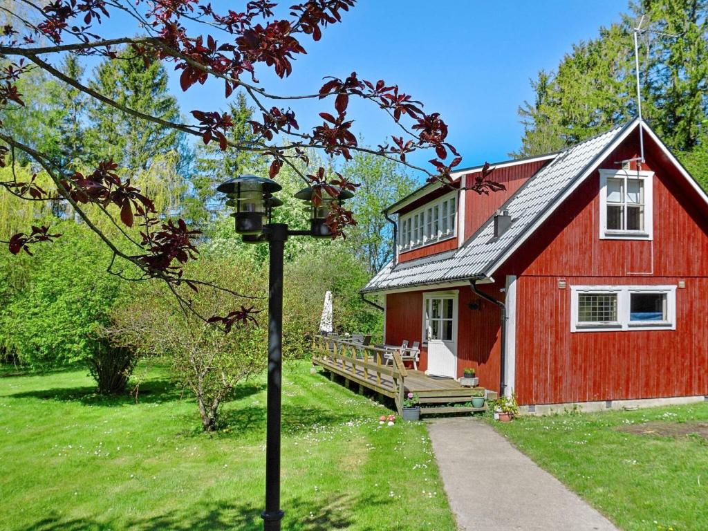 una casa roja con una lámpara delante en 4 person holiday home in HEMSE, en Hemse