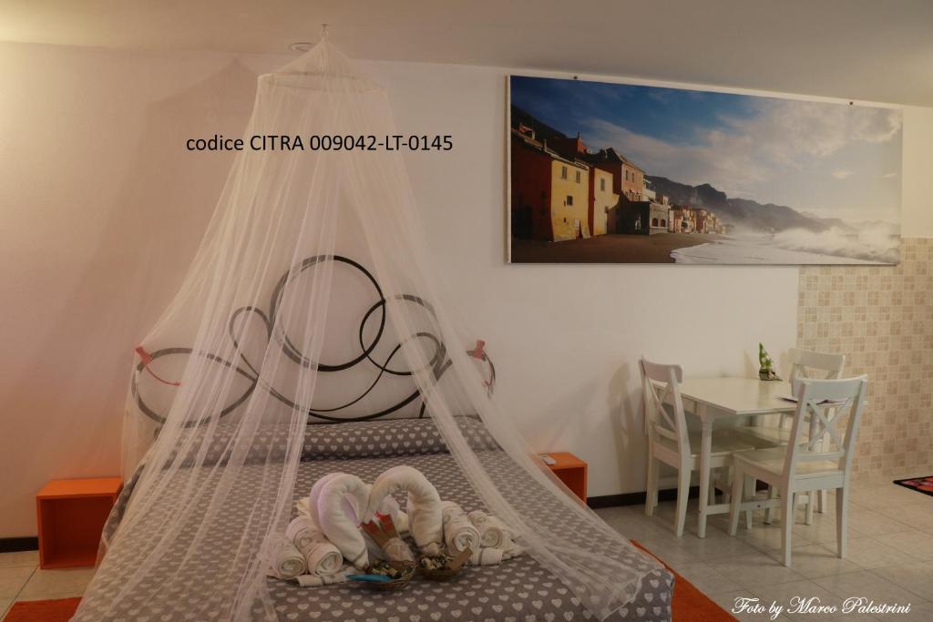 um quarto com uma cama de dossel e uma mesa em Casetta delle Fate , sport e natura em Noli