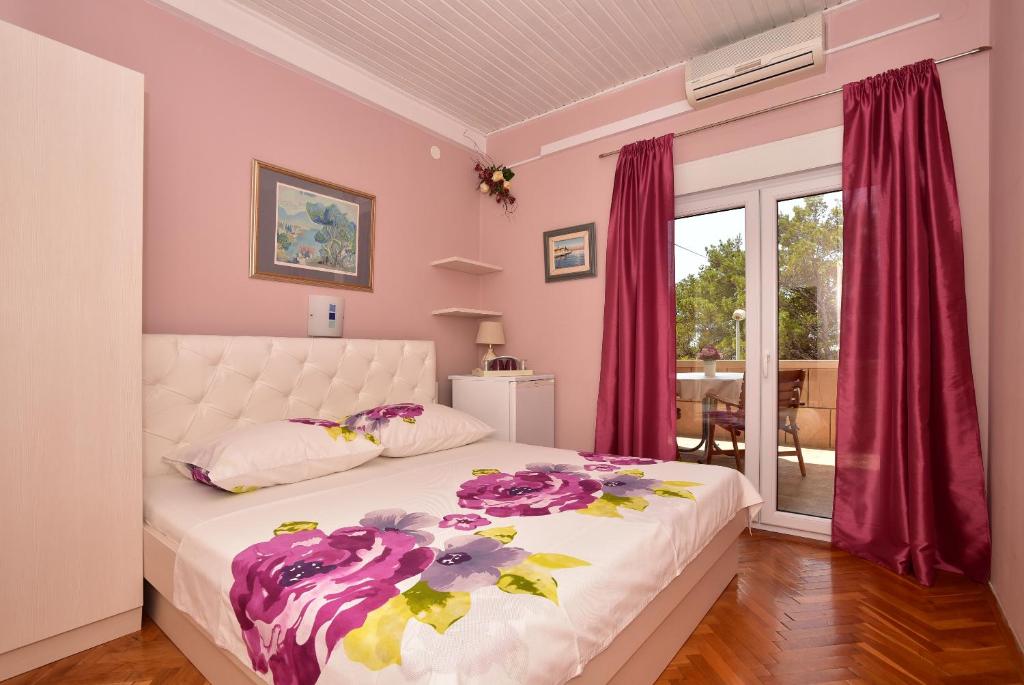 a bedroom with a white bed with pink walls at PINK 4 in Makarska
