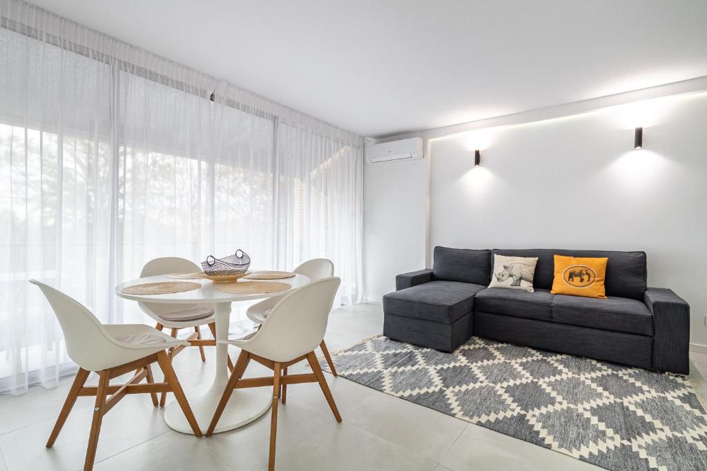 sala de estar con mesa, sillas y sofá en Comtal homey apartments, en Barcelona