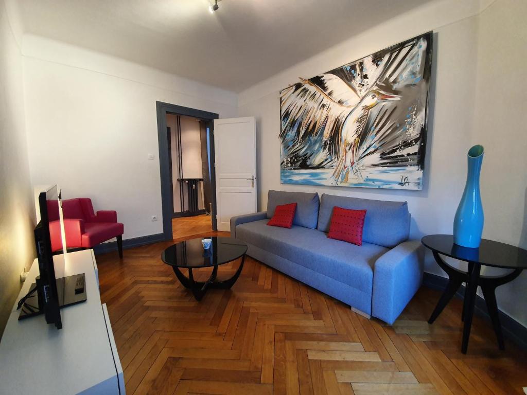 een woonkamer met een blauwe bank en een tafel bij Appartement Strasbourg Cathédrale in Straatsburg