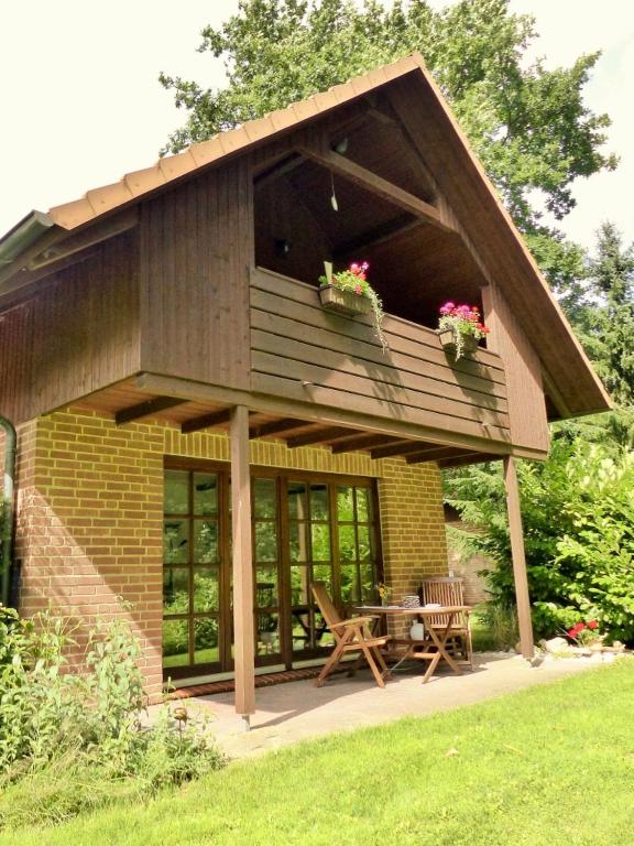 a house with a balcony and a table with flowers at Haus am Wald Klingberg in Klingberg