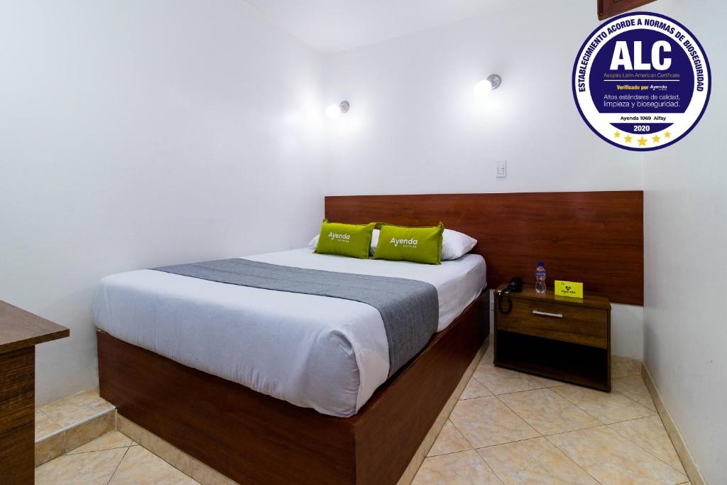 een slaapkamer met een bed en een bord aan de muur bij Ayenda 1069 Alfay in Bogota