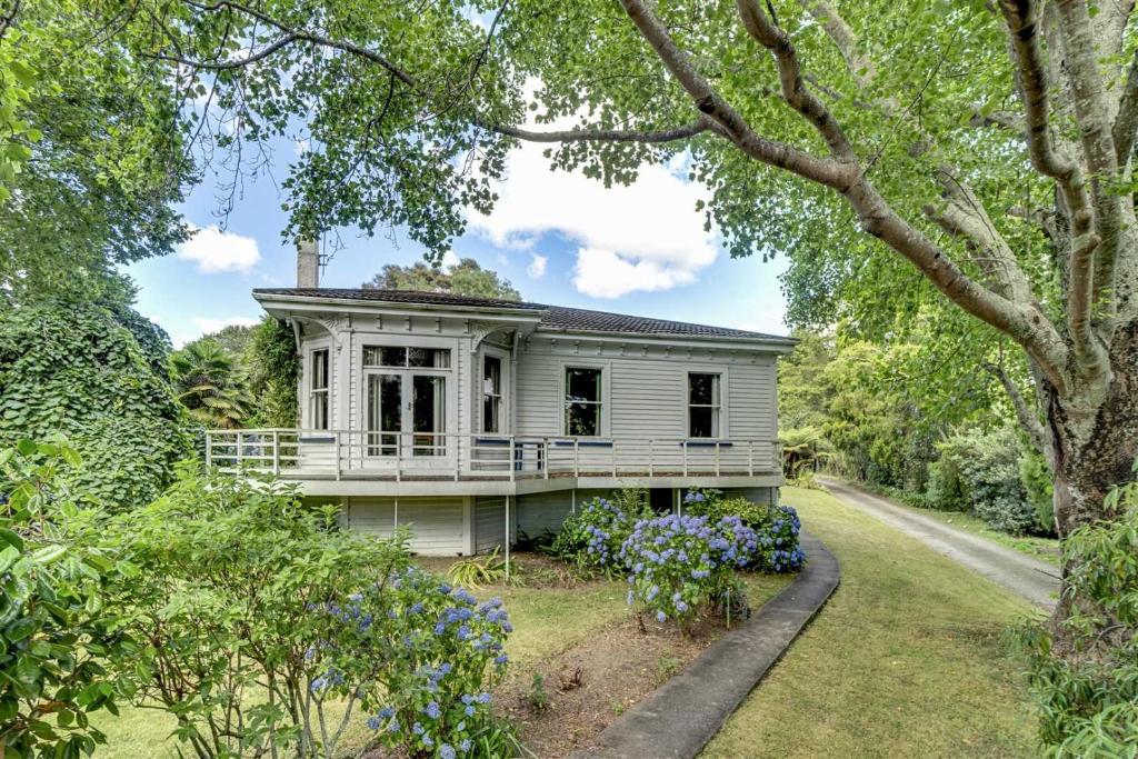 una casa blanca en medio de un patio en Elegant Villa Nestled In The Trees en Nelson