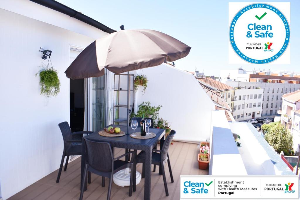 patio con mesa y sombrilla en el balcón en Terraço da Boavista en Oporto
