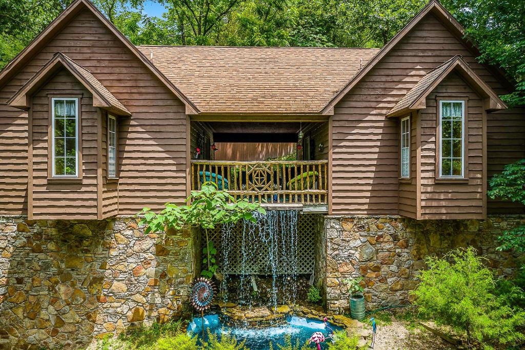 uma casa com uma varanda ao lado em The Woods Cabins em Eureka Springs