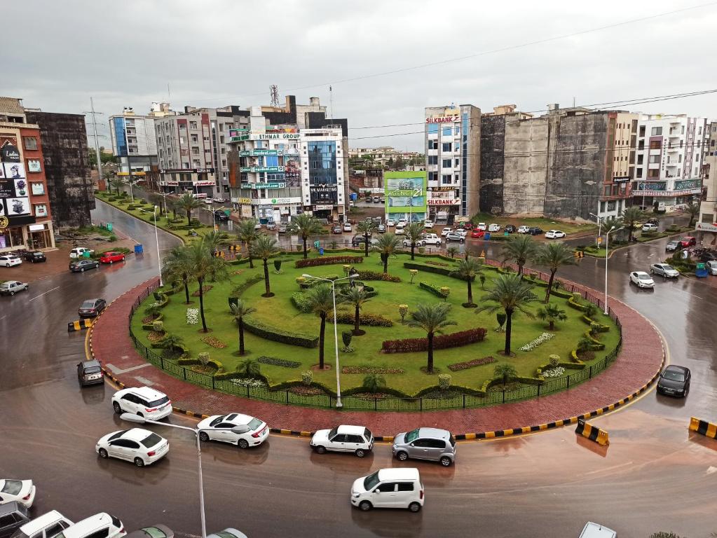 una città con auto parcheggiate in un parcheggio di HS Global Apartments a Rawalpindi