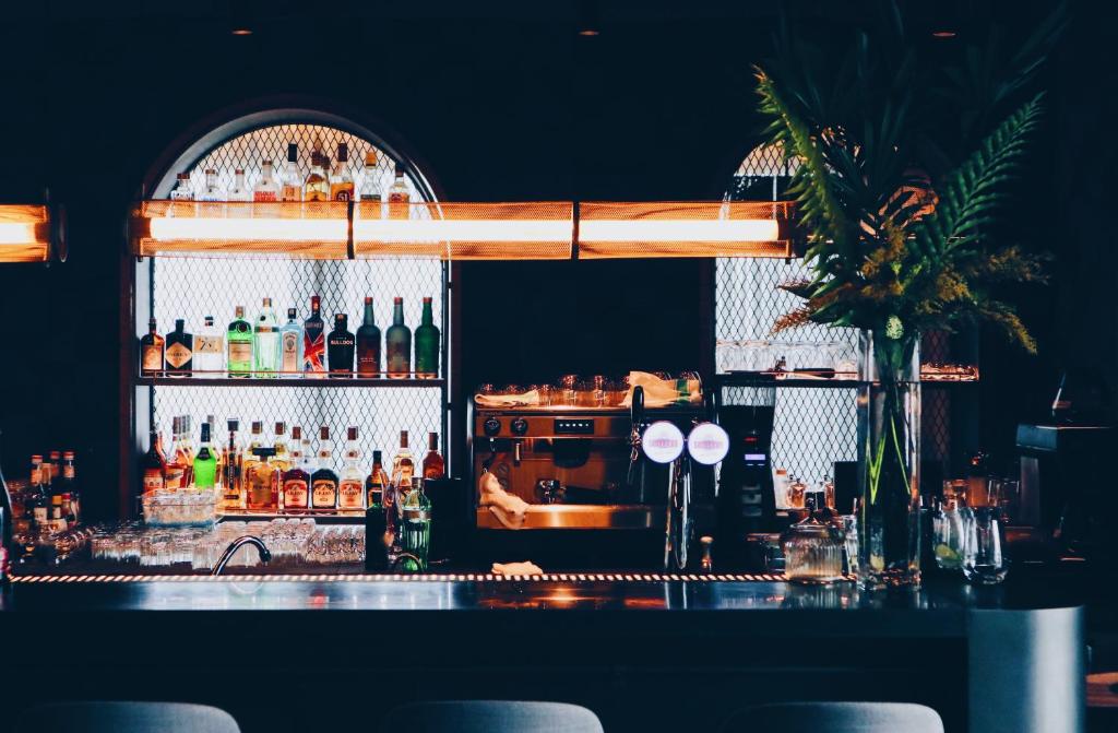 a bar with a lot of bottles of alcohol at Kimpton Da An Taipei- an IHG Hotel in Taipei