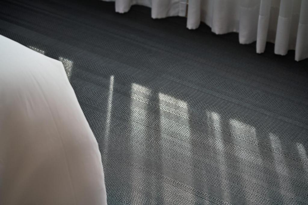 a bedroom with a bed and shadows on the floor at Kimpton Da An Taipei- an IHG Hotel in Taipei