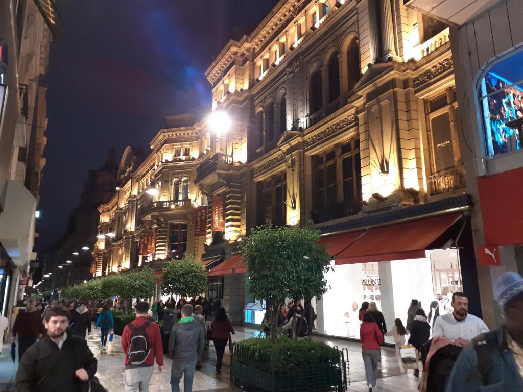 a group of people walking down a street at night at ApartFlorida1 in Buenos Aires