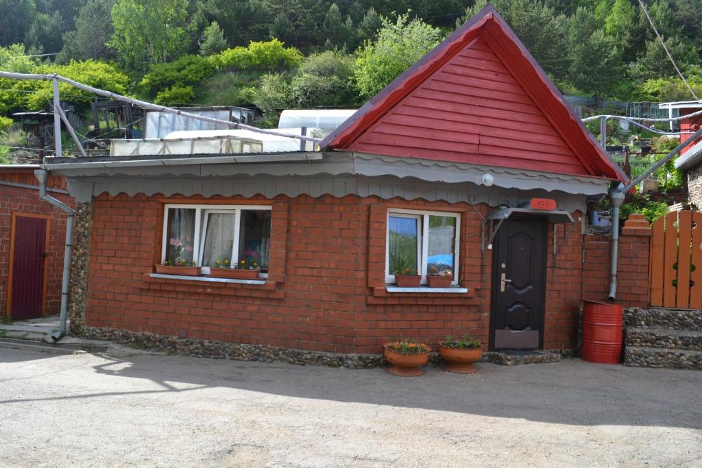 una pequeña casa de ladrillo con techo rojo en Lotsman Guest House, en Listvyanka