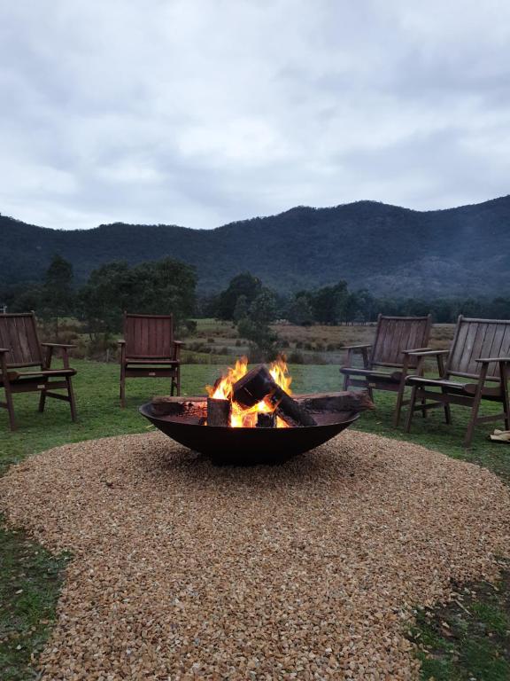a fire pit in the middle of a field with chairs at Halls Gap Motel in Halls Gap