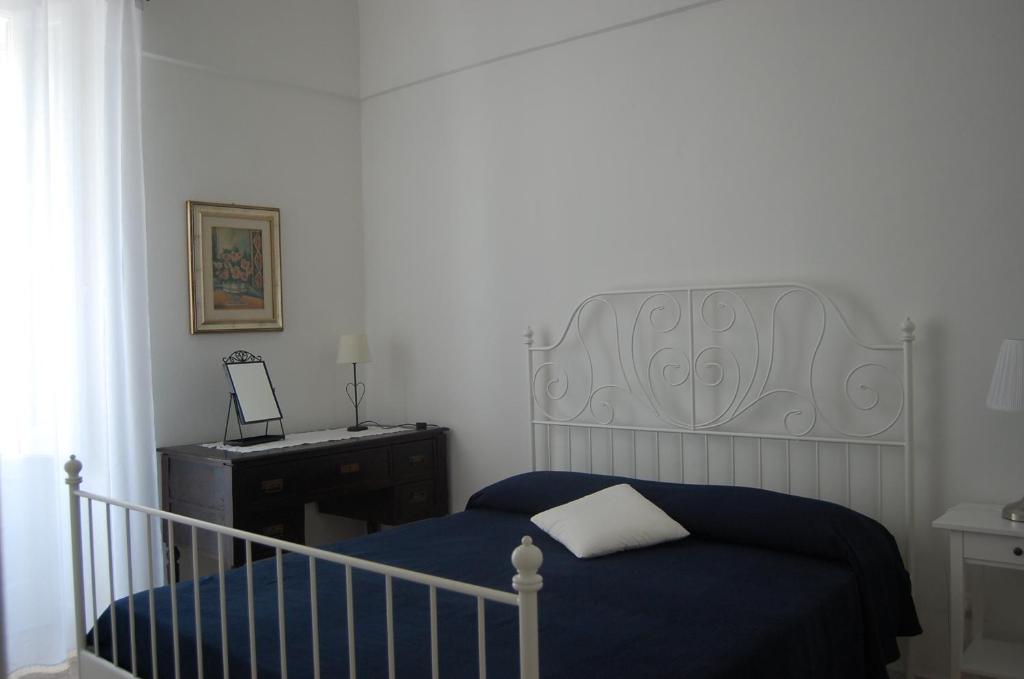ein Schlafzimmer mit einem blauen Bett, einer Kommode und einem Bettsenalsenalsenal in der Unterkunft casetta 35 in Monopoli
