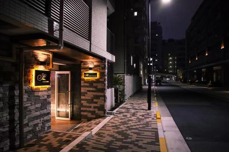 una calle de ciudad vacía por la noche con un edificio en Hotel Shu, en Tokio