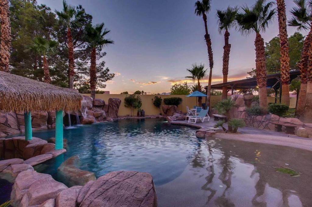 a swimming pool in a resort with palm trees at Villa Gordal - Enormous Villa in Las Vegas with 39 Sleeps in Las Vegas