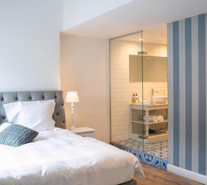 a bedroom with a bed and a glass shower at The Hamptons Boutique B&B in Ghent