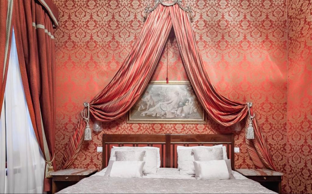 - une chambre dotée d'un lit avec un mur rouge dans l'établissement Casa Valier, à Venise
