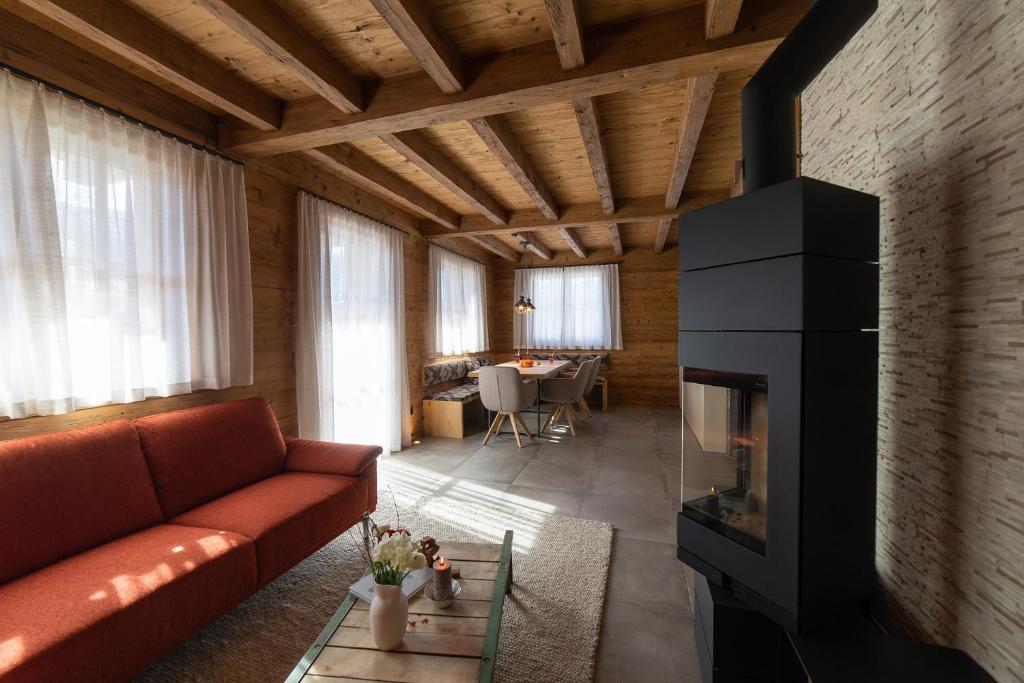 a living room with a couch and a fireplace at Chalet Schibenstoll in Wildhaus