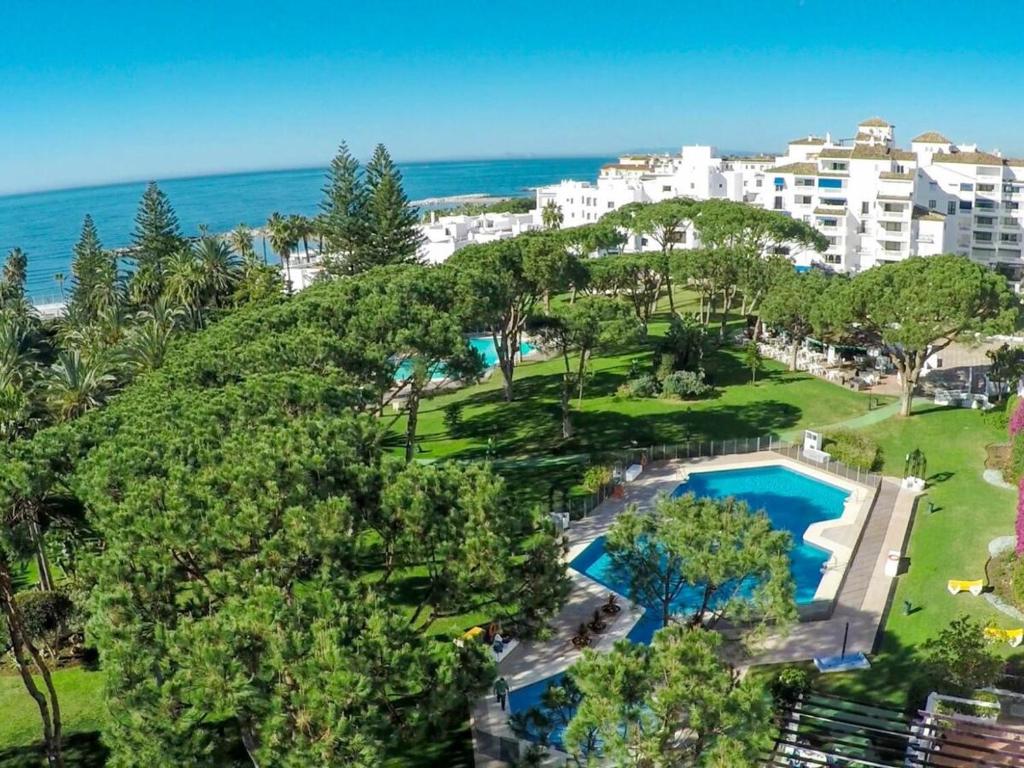 een luchtzicht op een resort met een zwembad en de oceaan bij Apartamento Playas del Duque - Puerto Banús - Marbella in Marbella