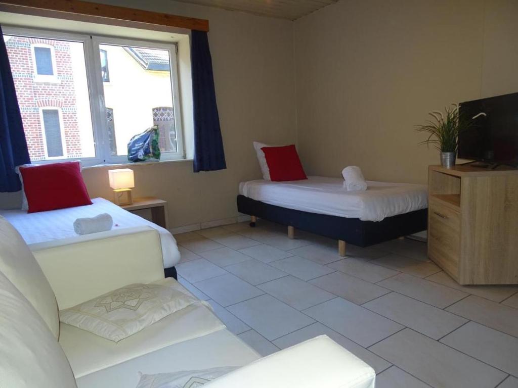 Zimmer mit 2 Betten, einem TV und einem Sofa in der Unterkunft Condo Gardens Leuven - Budget Studio Twin in Löwen