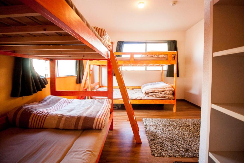 a room with two bunk beds and a hallway at DEER Hostel OSAKA NAMBA in Osaka