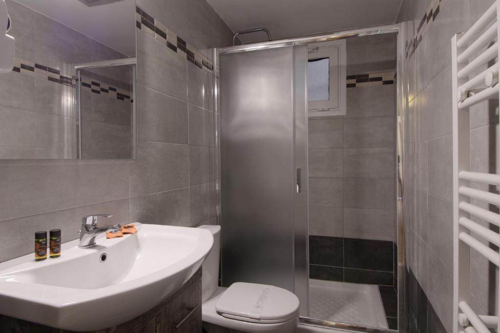 a bathroom with a sink and a toilet and a shower at Hotel Nefeli in Volos