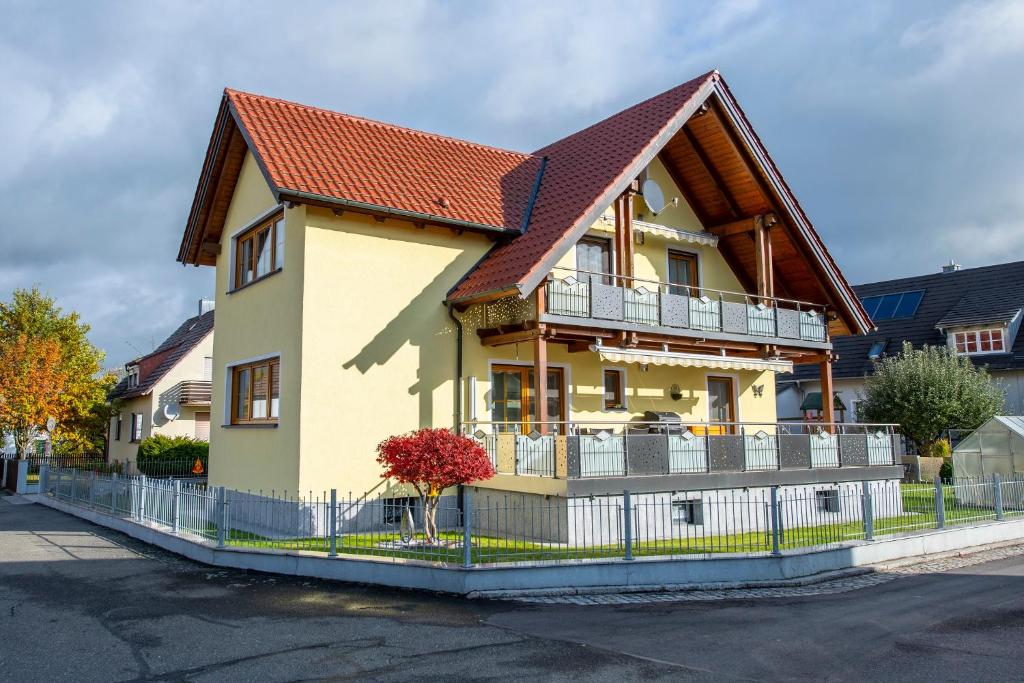 a yellow house with a brown roof at Ferienwohnung Forster in Moosbach