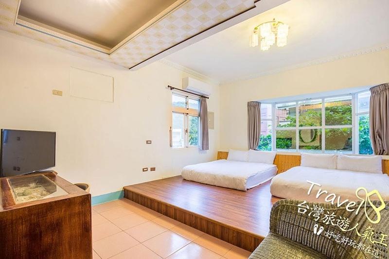 a living room with two beds and a tv at Blue Sea Romance B&amp;B in Green Island