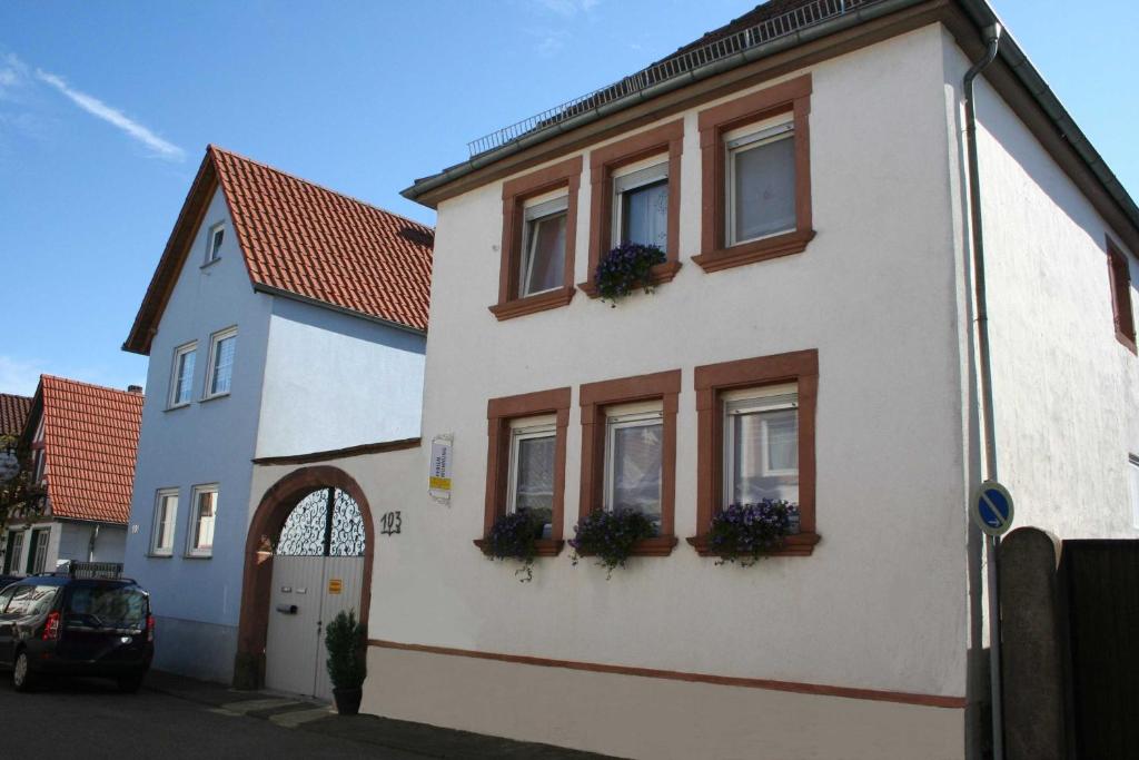 エデスハイムにあるFerienwohnung Spatzennest in Edesheimの窓と花の白い家