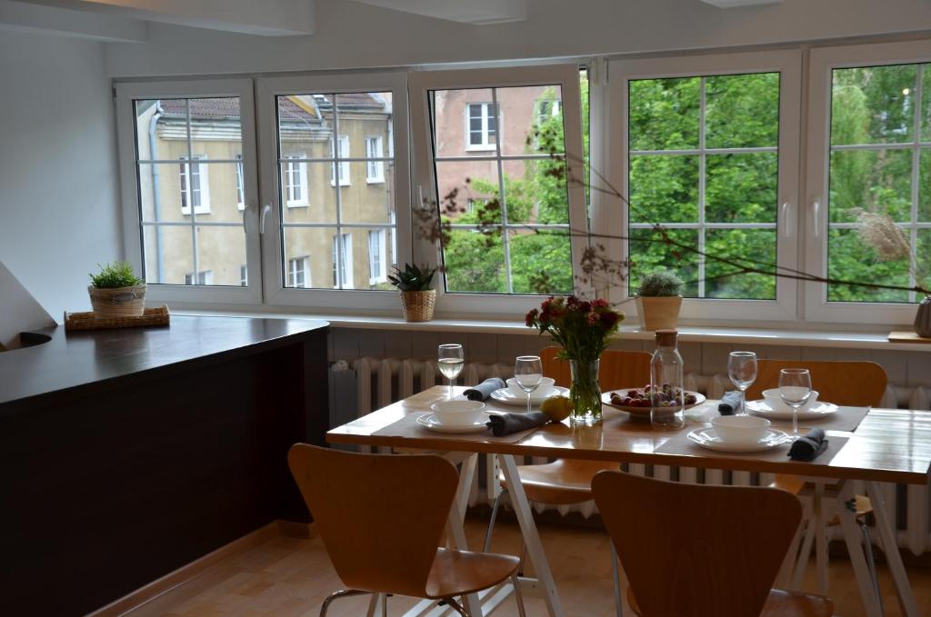 a dining room with a table and chairs and windows at INES apartament two Levels 105m2 in the Old Town wi-fi, netflix in Olsztyn