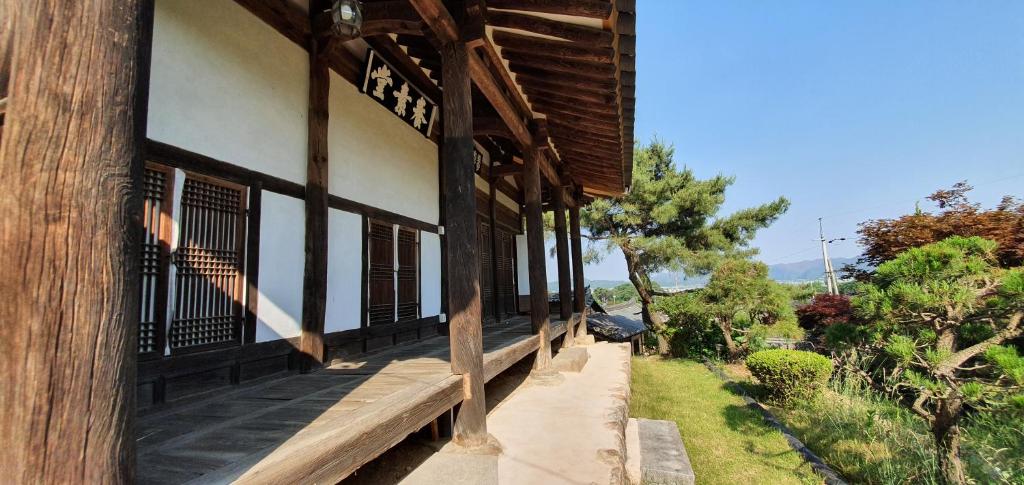 a building with a wooden bench on the side of it at Ahndong Kimjongtaek Yangsodang in Andong