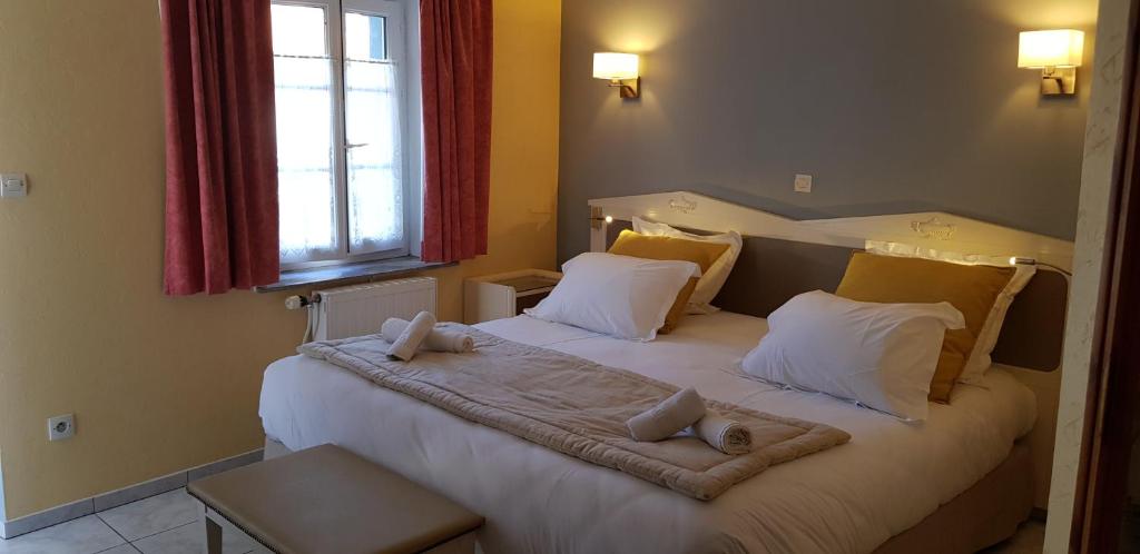a bedroom with two beds with pillows and a window at L'envie des mets in Rang-du-Fliers