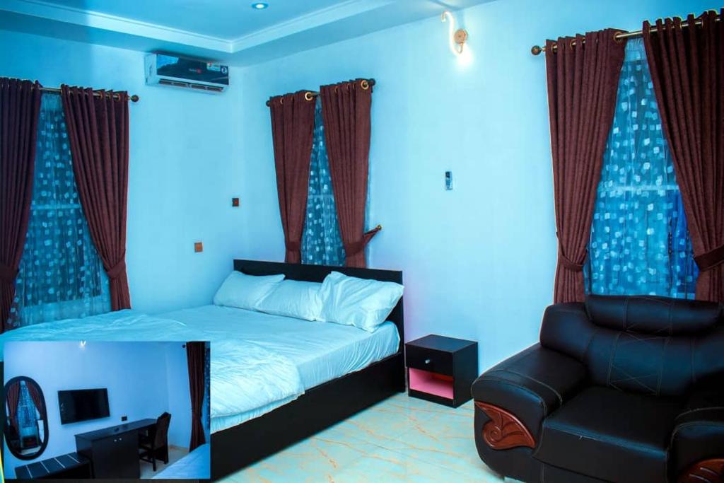 a bedroom with a bed and a chair at Mexiloyd Luxury Rooms & Suites in Port Harcourt