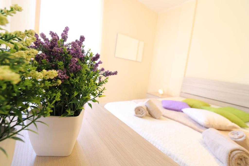 una camera con un letto e una pianta in vaso di In Good Location And With Balcony - Casa Vacanze Nicole In Salento a Otranto