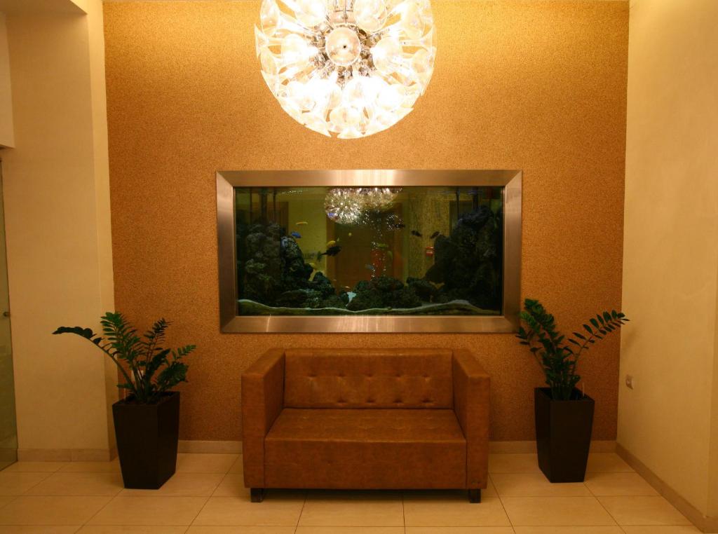 a waiting room with a couch and a large mirror at Hotel Flisvos in Kalamata