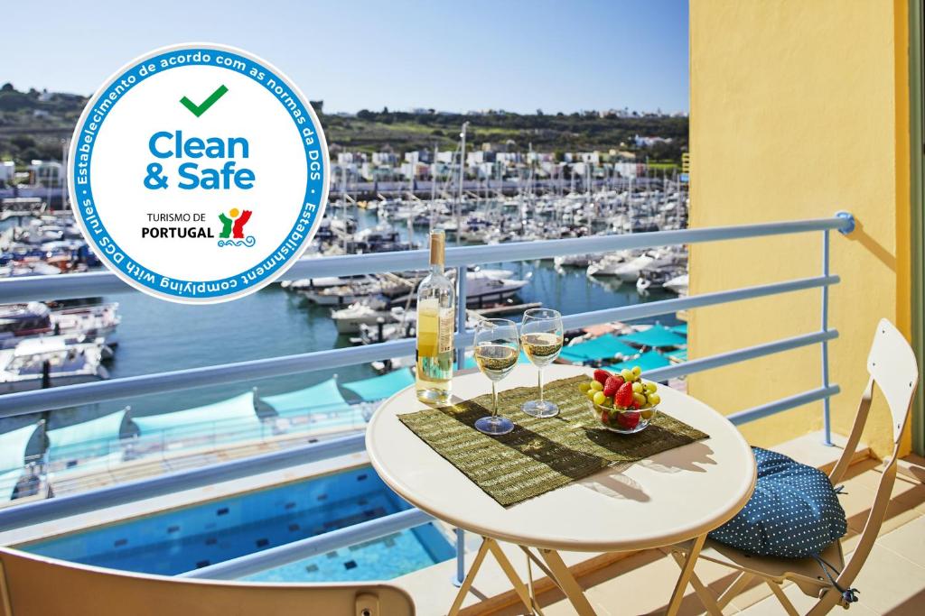 d'un balcon avec une table et des verres à vin et une vue sur le port. dans l'établissement Casas Barulho Albufeira Marina, à Albufeira
