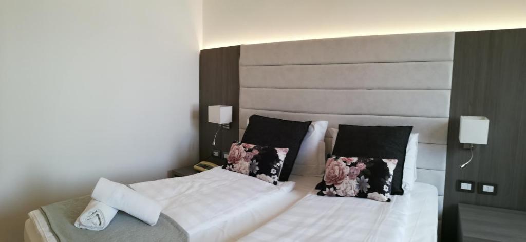 a bedroom with two beds with white sheets and pillows at Hotel Belvedere in Venice-Lido