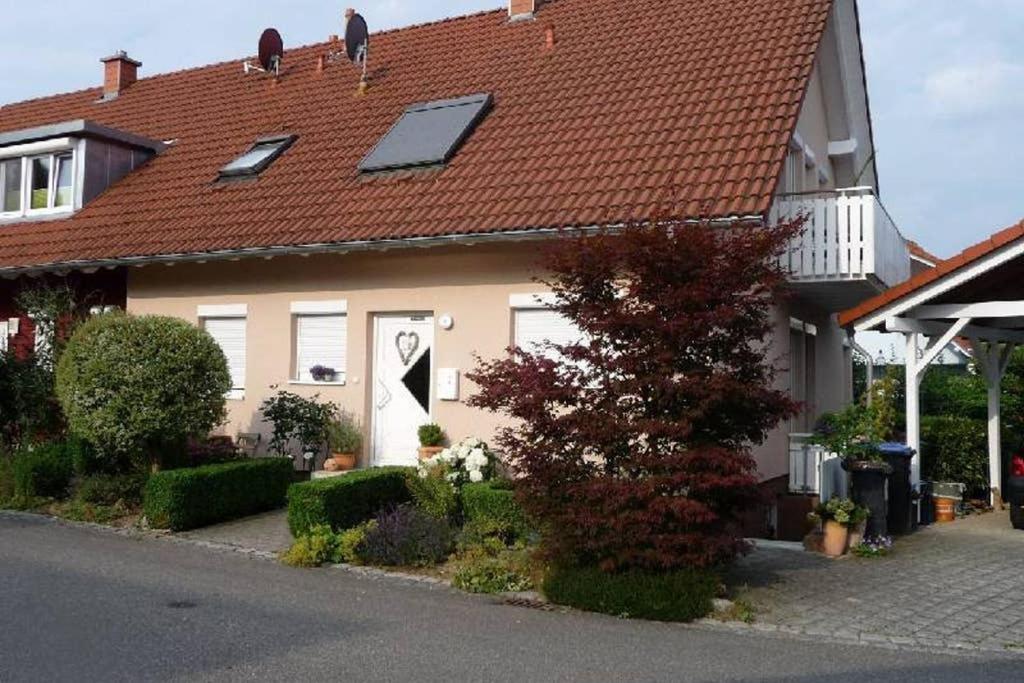 uma casa com um telhado vermelho com uma porta branca em Ferienwohnung Regina em Staufen