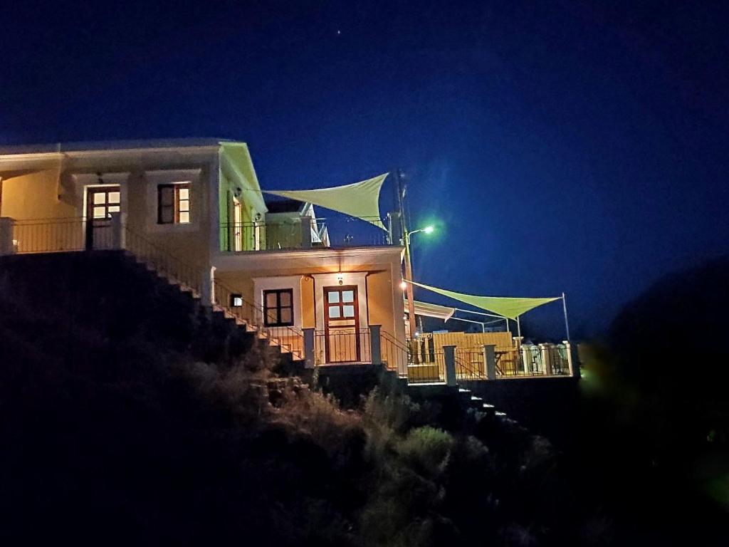 a house on top of a hill at night at Gompos Apartment - Cozy Apartment next to the sea - Amazing Sea View in Symi