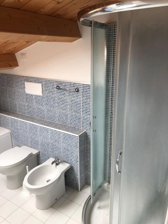 La salle de bains est pourvue de toilettes, d'un lavabo et d'une douche. dans l'établissement VILLA EMMA -WALTERIGATO Apartments SOLO PER FAMIGLIE, à Lido di Jesolo