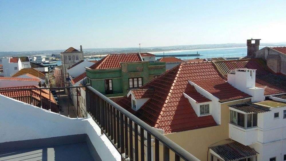 a view of roofs of buildings and the ocean at 66 Peniche in Peniche