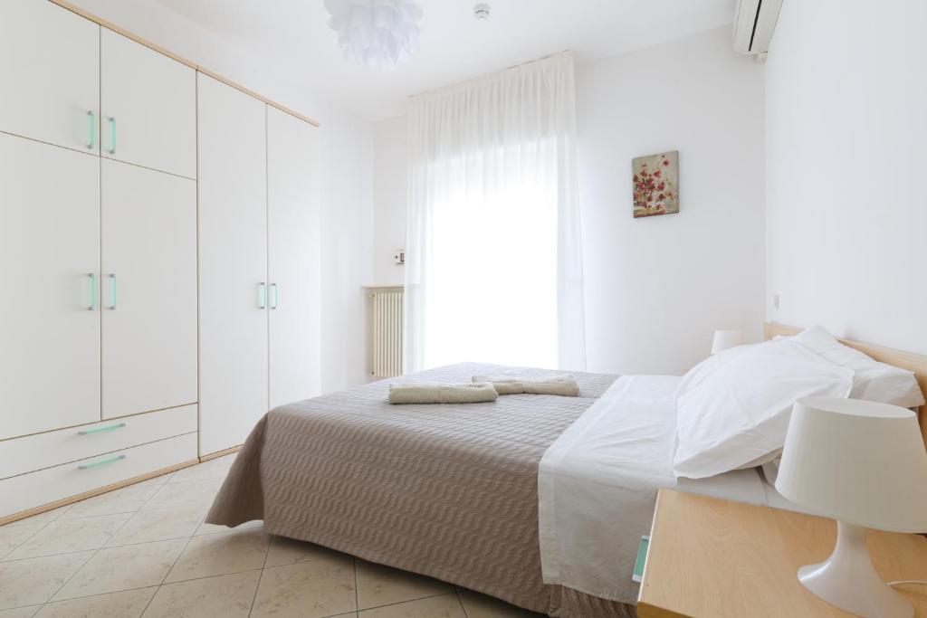 リミニにあるResidence Hotel Le Stelleの白いベッドルーム(ベッド1台、大きな窓付)