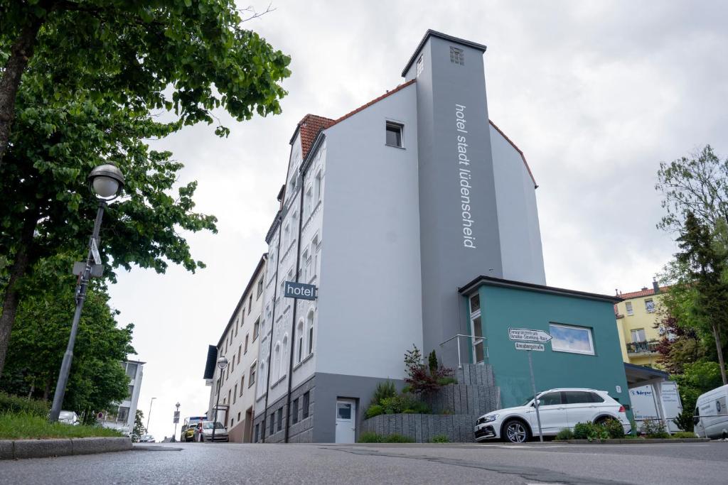 un edificio con un coche aparcado delante de él en Hotel Stadt Lüdenscheid, en Lüdenscheid