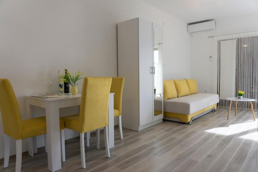 a living room with a table and chairs and a couch at Apartmani Ivković+ in Trebinje