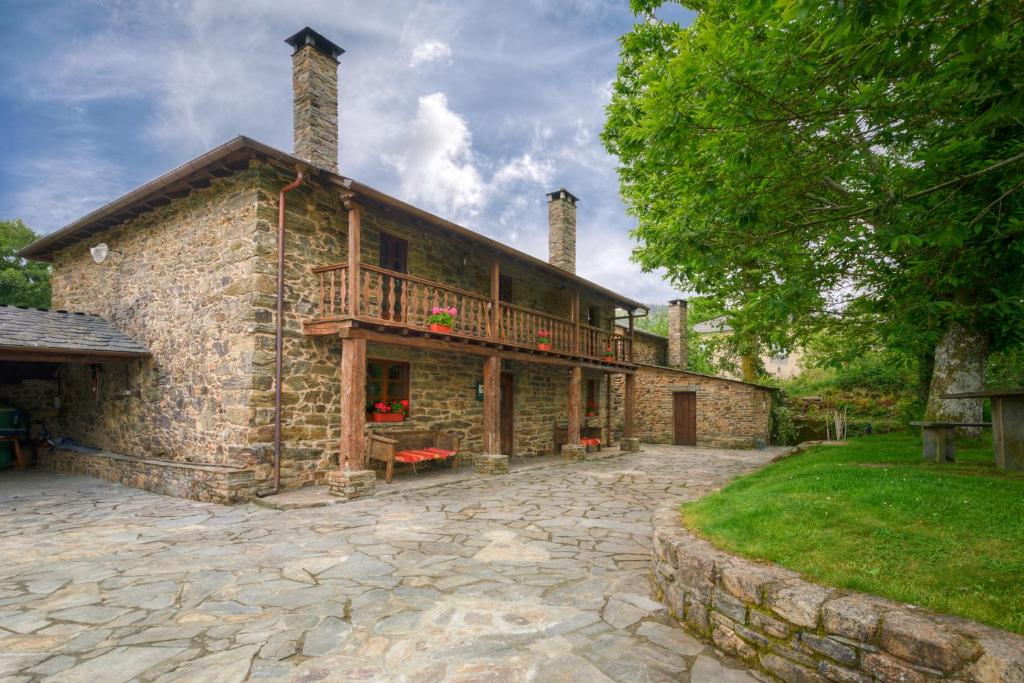 a large stone house with a balcony on it at Casa Bouza in Becerreá