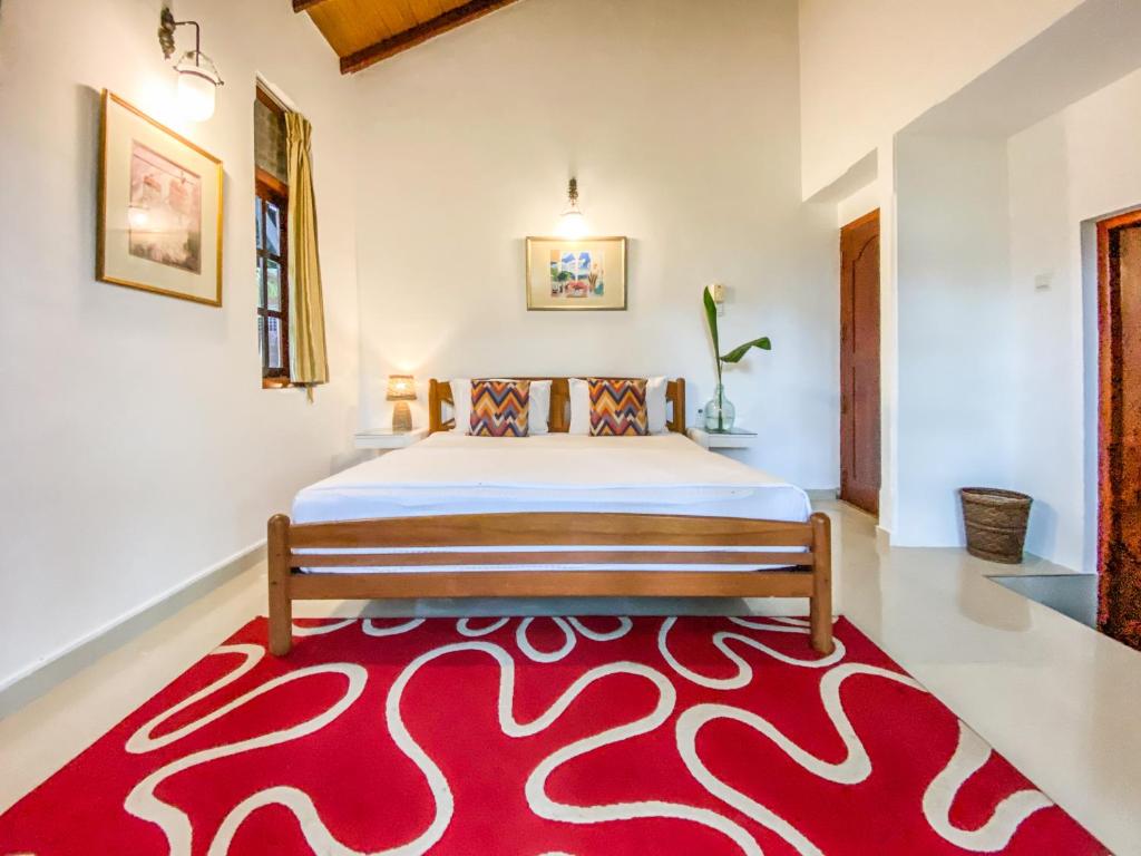 a bedroom with a bed and a red rug at Airport Green Olive Villa in Katunayaka