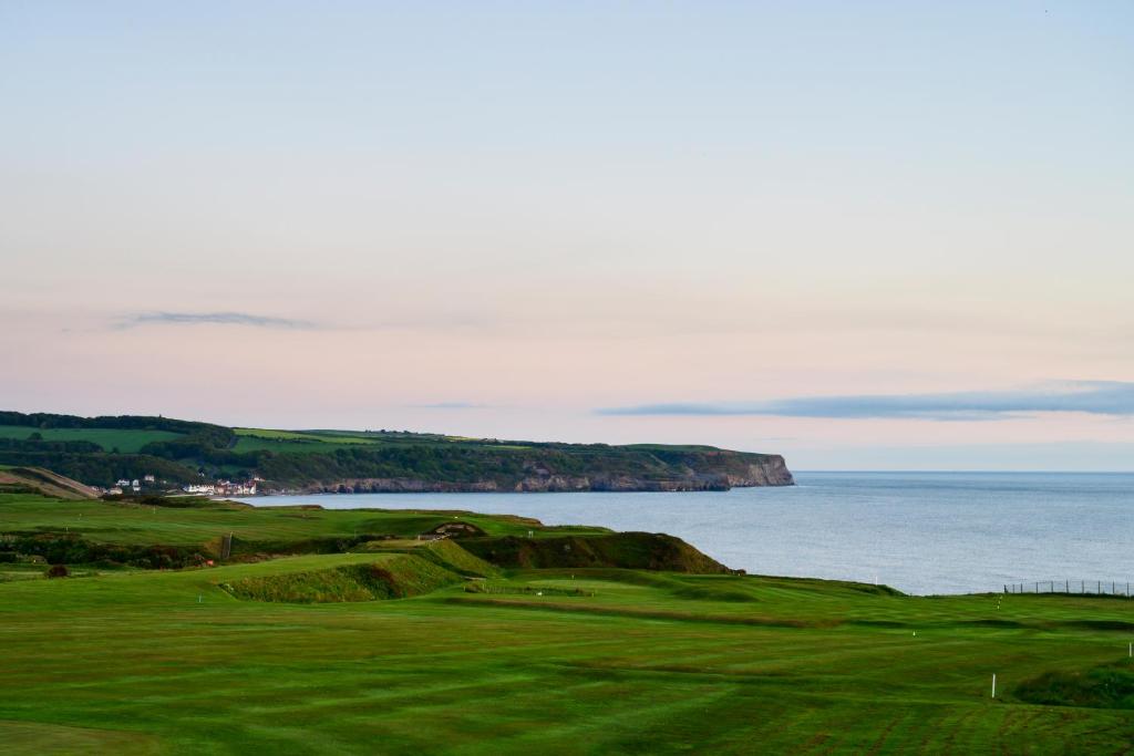 a golf course with the ocean in the background at The White House Inn - Whitby in Whitby