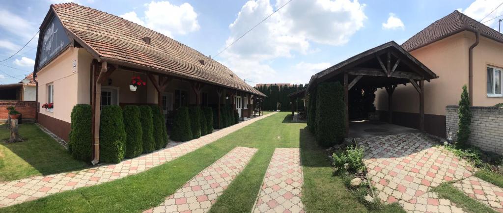 una casa con un patio verde al lado de un edificio en Apartman u Karla, en Veľký Meder