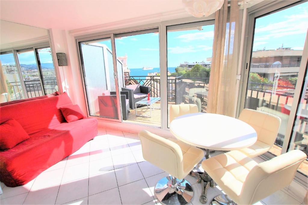 un salon avec un canapé rouge et une table dans l'établissement Nice apartment last floor with terrace and clear view on the sea, à Cannes