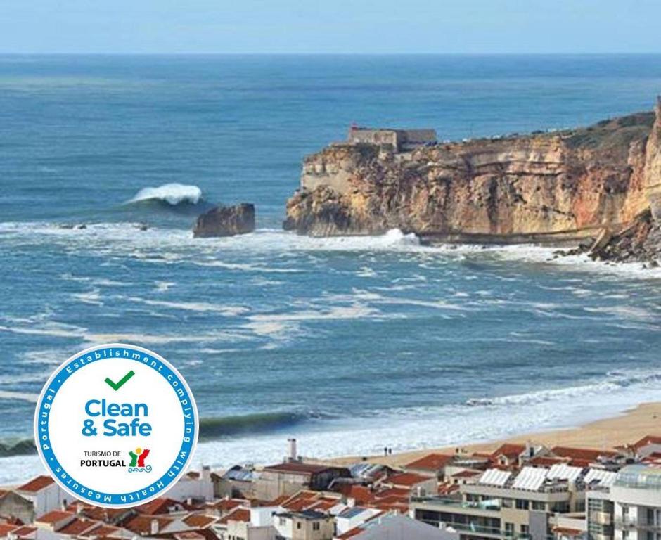 un cartello che dice pulito e sicuro vicino all'oceano di Hospedaria A Primorosa a Nazaré